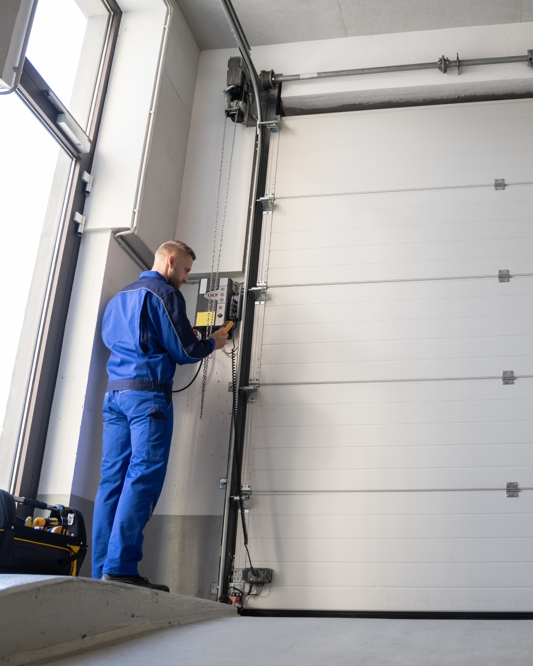 Technician completing garage door opener repair in Calgary